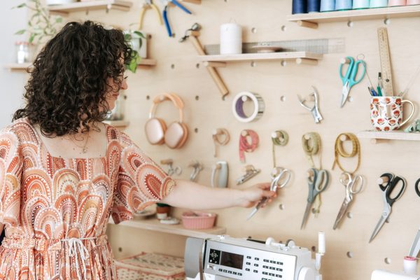 Plywood pegboard storage wall for sewing tools in the Megan Nielsen Patterns workroom