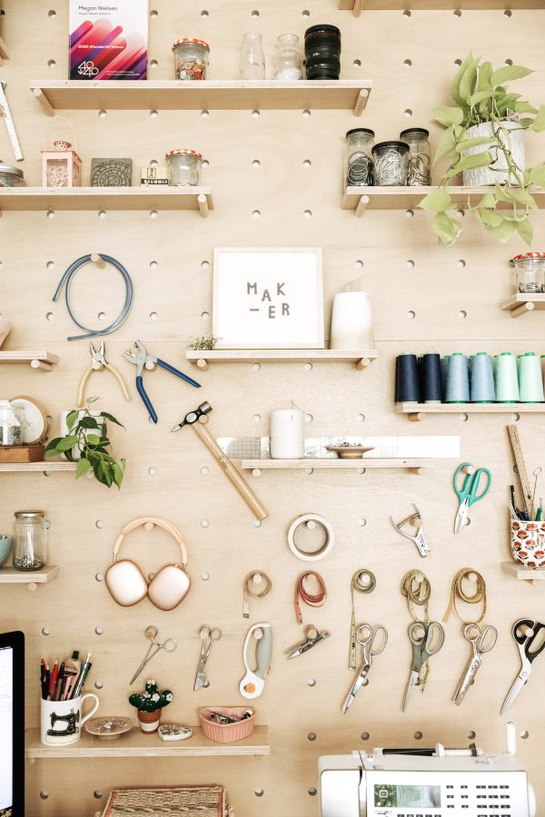 Plywood pegboard storage wall for sewing tools in the Megan Nielsen Patterns workroom