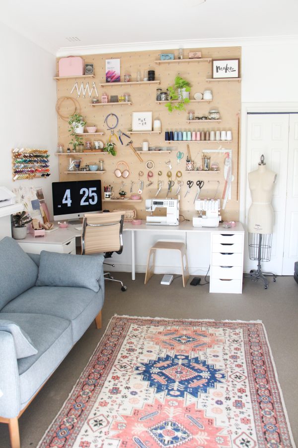 Megan Nielsen Workroom Tour 2025. Giant custom plywood pegboard wall with corner desk.