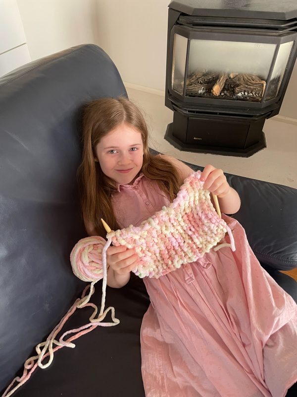 Birdie knitting her own scarf